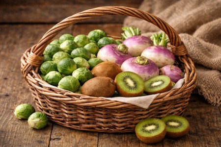 Un panier de navets, choux de Bruxelles et kiwi